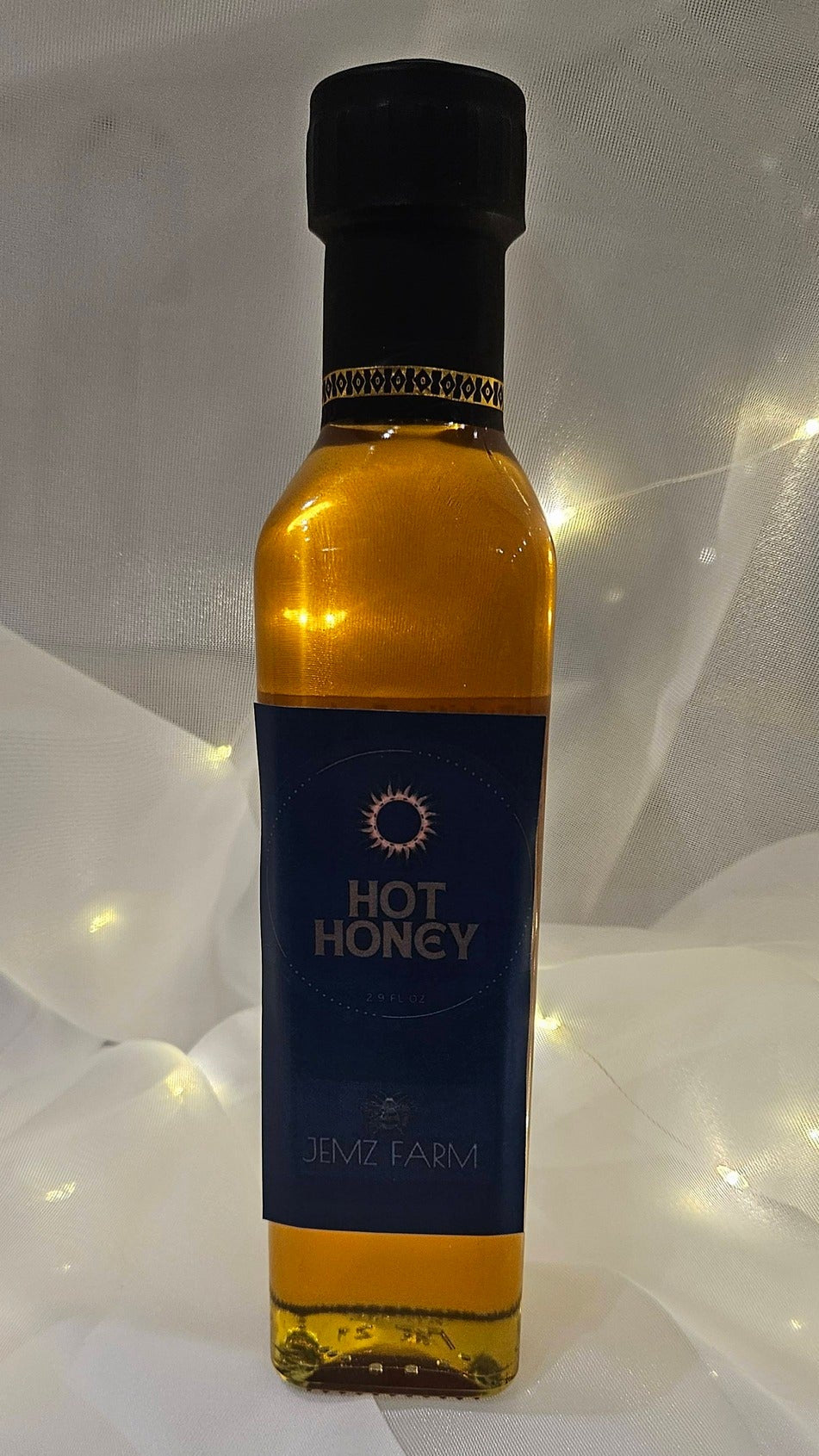 Bottle of hot honey with a black cap on a white background