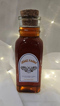 Small glass bottle with cork lid labeled 'Jemz Farm' on a white background