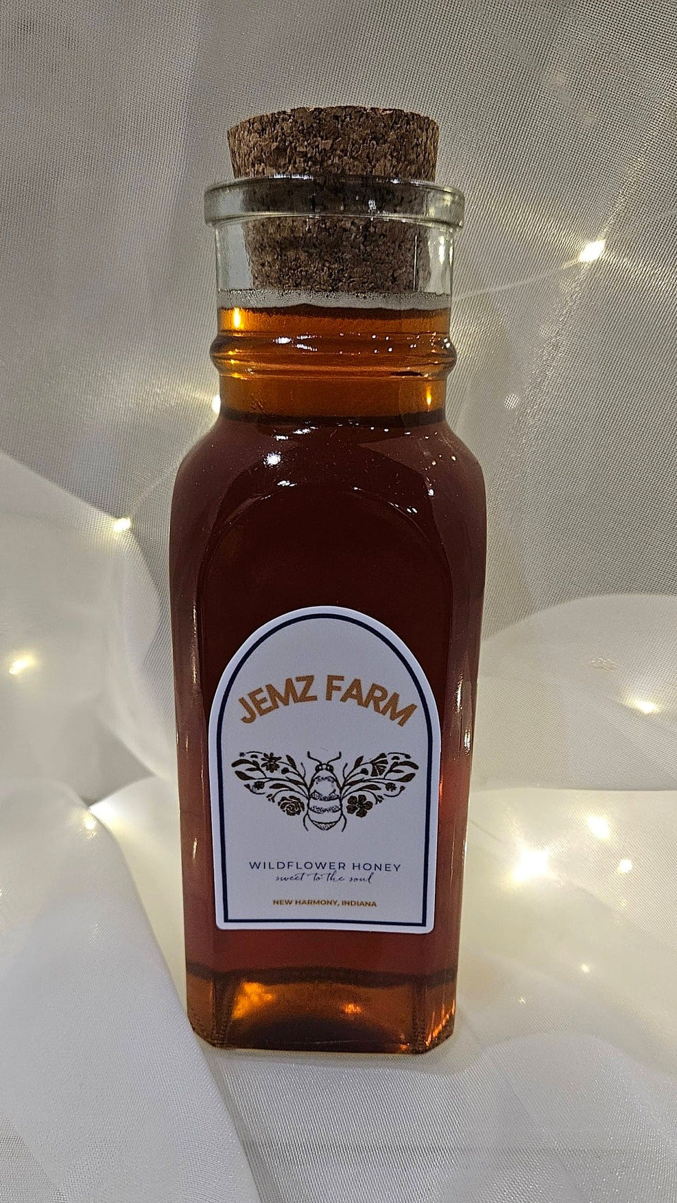 Small glass bottle with cork lid labeled 'Jemz Farm' on a white background