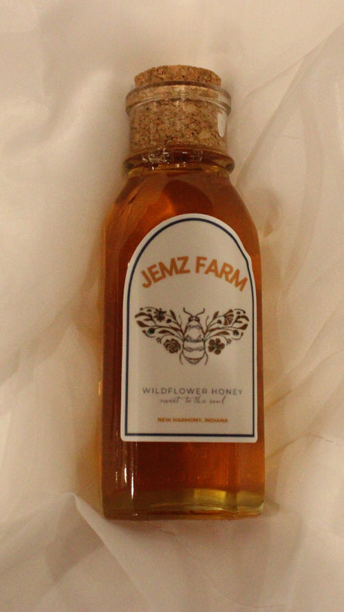 Bottle of honey from Hemz Farm on a white fabric background